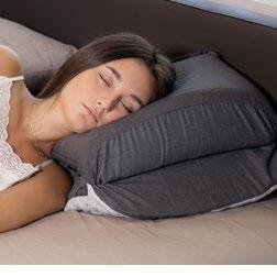 Close-up of the Starvion pillow supporting a person's lower back while sitting on a sofa